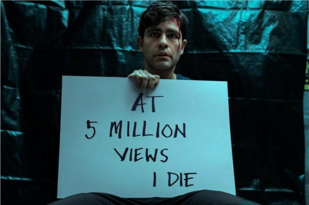 Adrian Grenier como Nick Brewer na série Clickbait segurando uma placa escrita "Aos 5 milhões de visualizações, eu morro" (Imagem: Divulgação/Netflix)